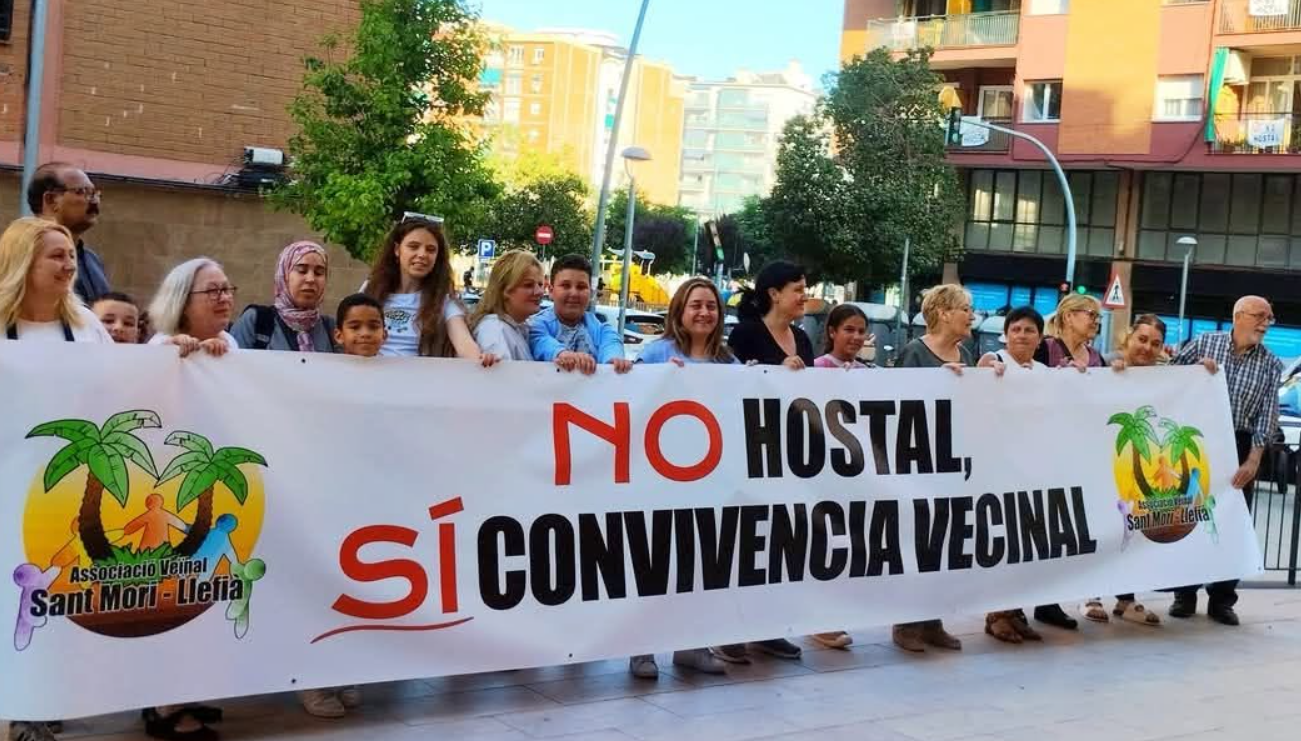 Vecinos y vecinas sosteniendo la pancarta «No hostal, sí convivencia vecinal»